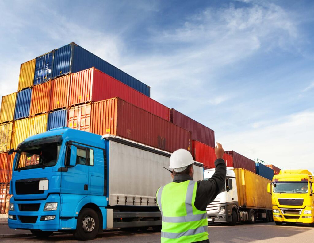 a worker with his hand up signaling truck drivers to come through