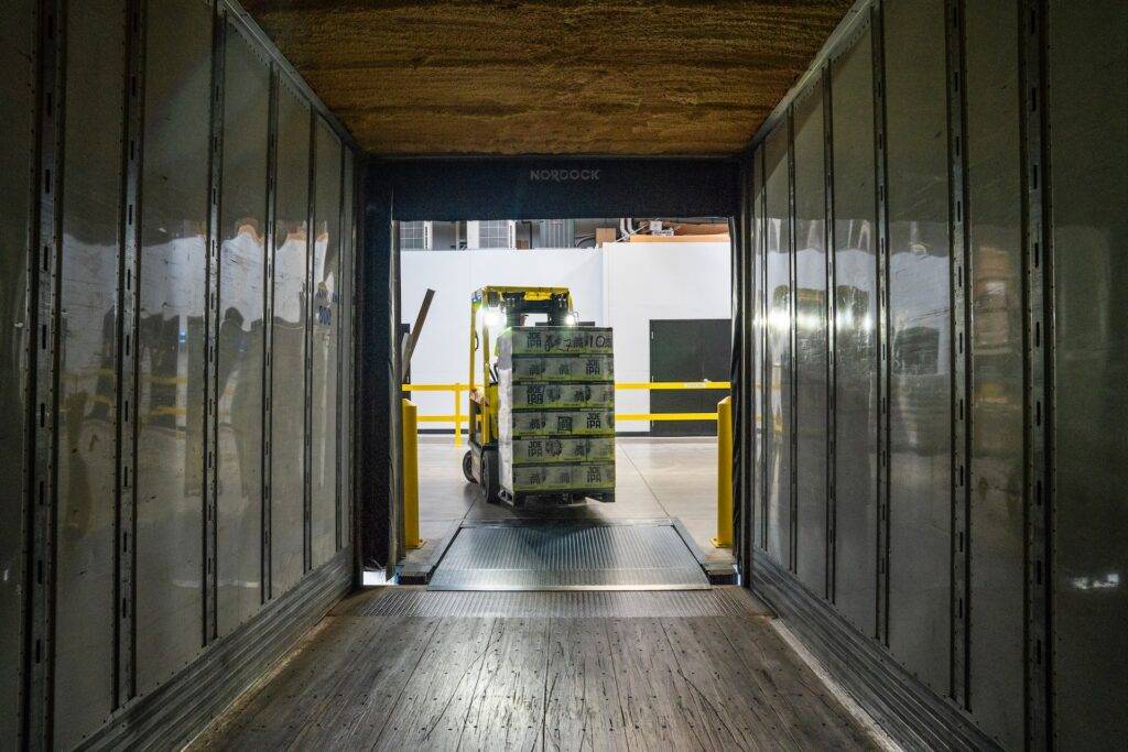 A worker drives a forklift to transport merchandise for a logistics company.